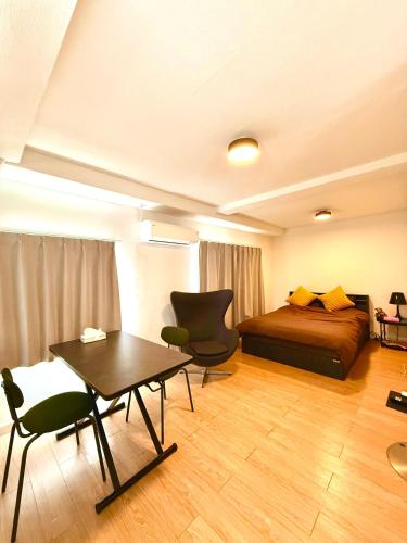 a bedroom with a bed and a table and chairs at home shinjuku west301 in Tokyo