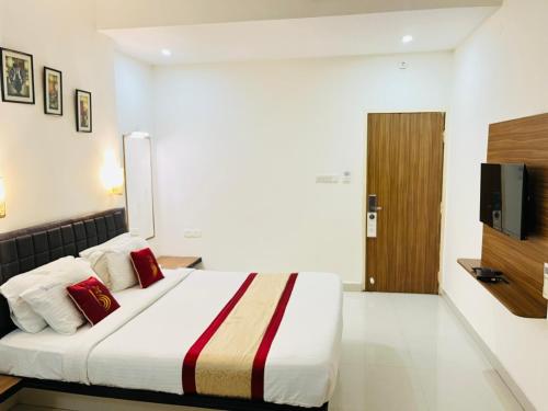a hotel room with a bed and a television at Hotel Grand Bee , Yeshwanthpur Junction in Bengaluru