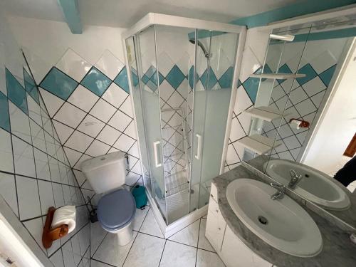 une salle de bain avec un lavabo, une douche et des toilettes dans l'établissement Villa Jean proche port et haute ville, à Porto-Vecchio