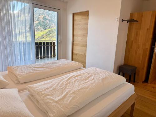 two beds in a room with a window at Ferienwohnungen Preiss in Schenna