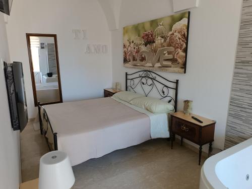 a bedroom with a bed and a table and a mirror at Sweet love Chiarelli in Ceglie Messapica