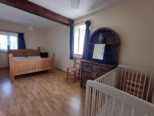 - une chambre avec un lit et un lit bébé dans l'établissement La grange, à Taillebois