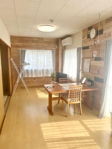 a room with a desk and a table and chairs at オレンジコーポ 201号室 in Arao