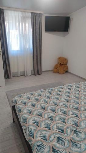 a teddy bear sitting on a bed in a bedroom at Casa M&V in Focşani
