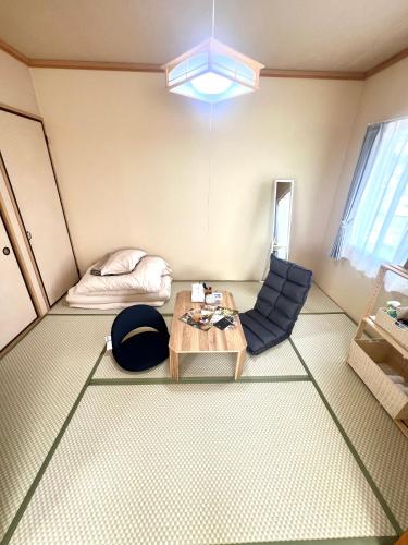 a living room with a table and a bed at オレンジコーポ 201号室 in Arao