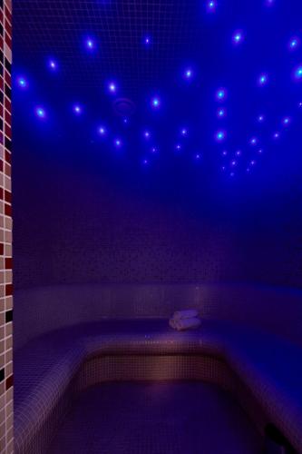 a bathroom with a tub with lights on the ceiling at Arte & Mare Elia Luxury Suites and Villas in Elia Beach