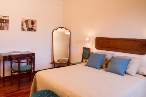 a bedroom with a bed with blue pillows and a mirror at Agriturismo Borgo dei Ricci in Impruneta
