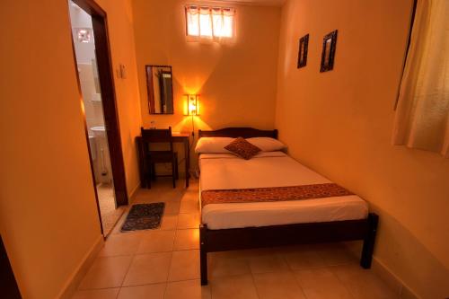a small bedroom with two beds in a room at Andrea Hotel in Yogyakarta