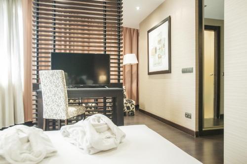 a hotel room with a desk and a computer at AZZ Asturias LangreHotel & Spa in Langreo