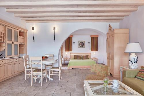 a living room with a bed and a table at Arte & Mare Elia Luxury Suites and Villas in Elia Beach