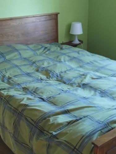 - un lit avec une couette bleue et jaune dans l'établissement La Montagnarde, à Cézens