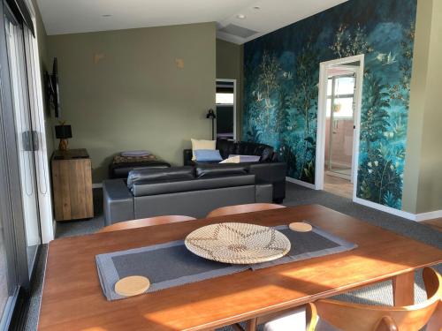 una sala de estar con un sofá y una mesa en New two bedroom close to town, en Taupo