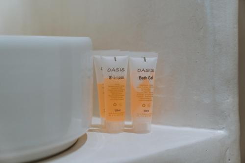 two bottles of sunscreen on a counter next to a laptop at Trouhalos Apartment in Livadion