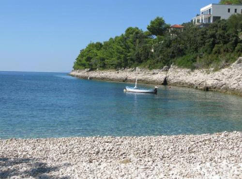 una barca in acqua su una spiaggia rocciosa di Beachfront Luxury Villa with Private Pool and Stunning Sea Views a Korčula
