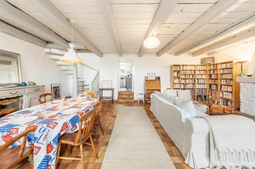 une salle à manger avec une longue table et des chaises dans l'établissement Bisquine - Maison 3 chambres - Jardin clos, à Cancale