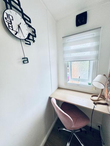 a room with a desk and a clock on the wall at Võsu Rent SIPELGAPESA Puhkemaja in Võsu