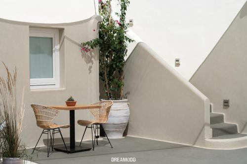 a patio with a table and chairs and stairs at Edem Boutique Suites in Oia
