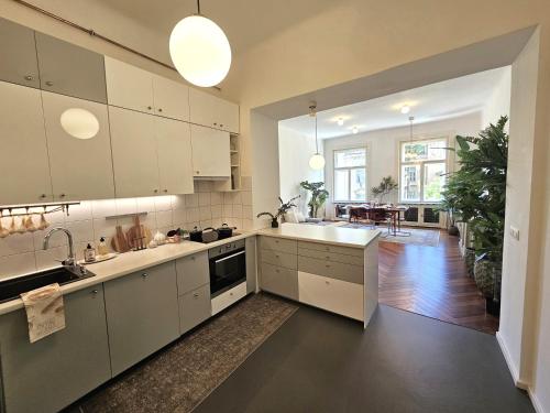 une cuisine avec des placards blancs et une salle à manger dans l'établissement Design Old Town Aprt - Blue Church & Park - AC, à Bratislava