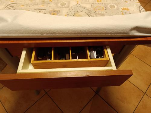 a wooden drawer on a table next to a bed at Mansarda Eiretta in Ceres