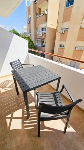 a picnic table and a chair on a balcony at Central City Rooms in Larnaca