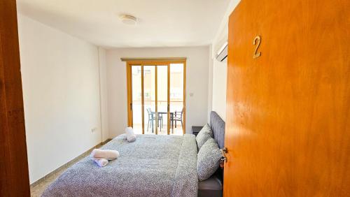 a bedroom with a bed and a wooden door at Central City Rooms in Larnaka