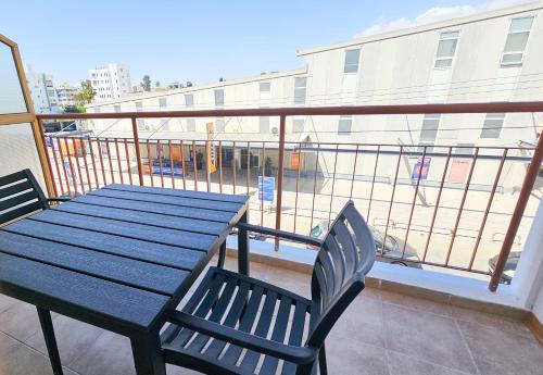 a blue table and chairs on a balcony with a building at Central City Rooms in Larnaka