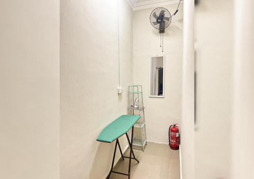 a white room with a stool and a green counter at ALAN TRANSIT MOTEL - Klia in Sepang