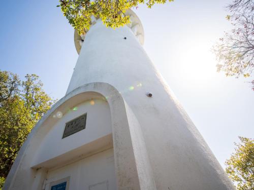 a small white building with a tower on top of it at Glamprook Shimanami in Imabari