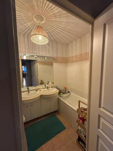 une salle de bain avec deux lavabos, une baignoire et un miroir dans l'établissement Superbe Appartement avec Piscine - Grasse, à Grasse