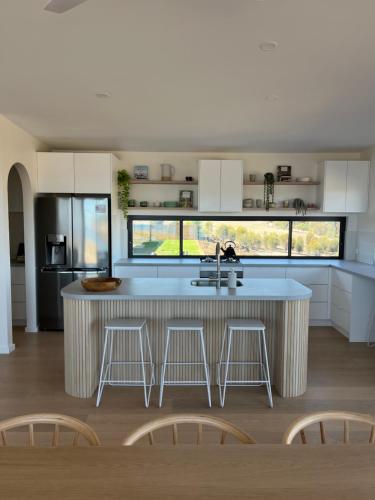 een keuken met een groot keukeneiland met barkrukken bij Coast in Stokes Bay