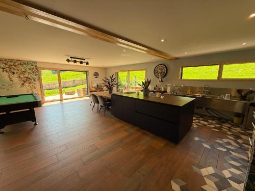 a large living room with a kitchen and a pool table at LES ANTHOCYANES in Champagny
