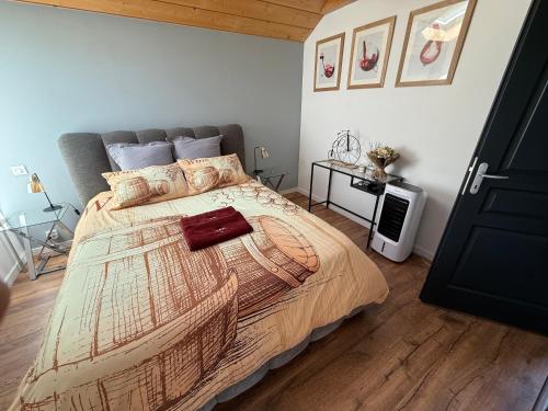 a bedroom with a large bed and a table at LES ANTHOCYANES in Champagny