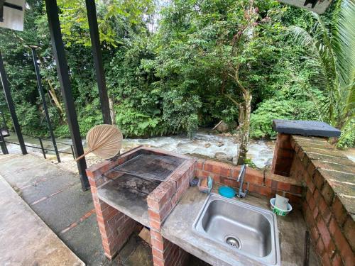 a outdoor kitchen with a sink on a patio at Casa Damai Janda Baik - RIVERVIEW TINY HOUSE in Bentong