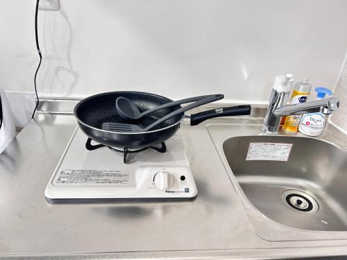 a frying pan sitting on top of a counter next to a sink at Y-Shinjuku City, Okubo 3F-SJ0069 in Tokyo