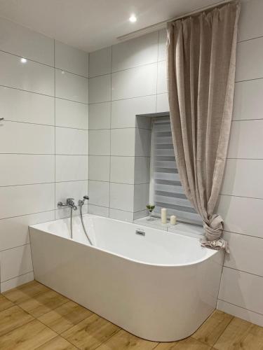 a white tub in a bathroom with a window at chillout w Rychwaldzie in Żywiec