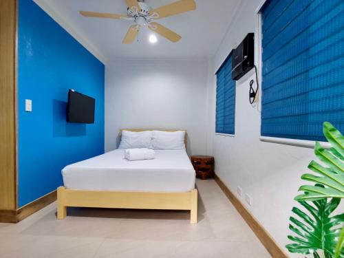 a bedroom with a bed and a ceiling fan at Den Den Guesthouse in Basco