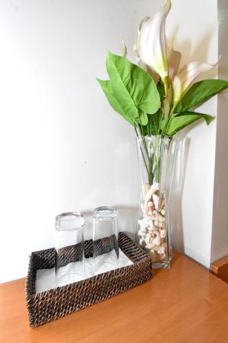 a vase with a flower and two glasses on a table at Blue Lotus Hotel in Boracay