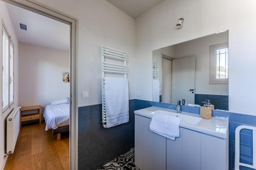 une salle de bain avec un lavabo et un miroir dans l'établissement Villa Mistral Pyla-sur-Mer, à La Teste-de-Buch