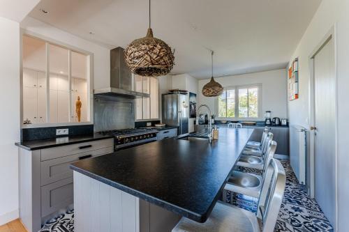 une cuisine avec un comptoir noir dans une pièce dans l'établissement Villa Mistral Pyla-sur-Mer, à La Teste-de-Buch
