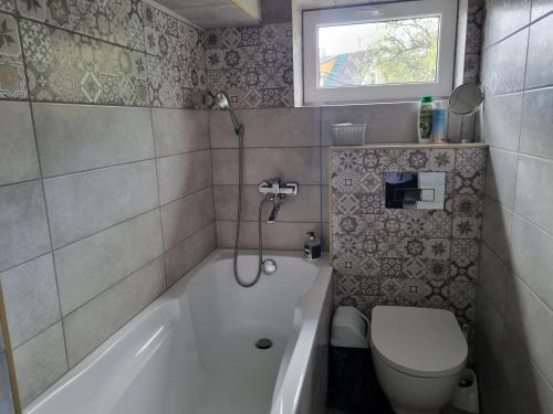 a bathroom with a toilet and a tub and a sink at Nakvynė Akmenėje -Pušyno pašonėje in Akmenė