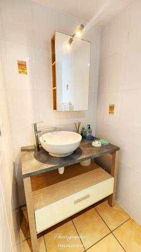 une salle de bain avec un lavabo blanc et un miroir dans l'établissement Entre Mer et Lac, à Aytré