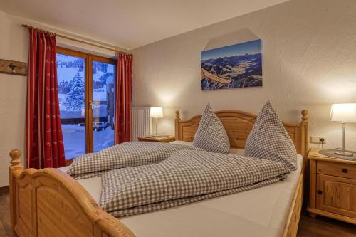 a bedroom with a bed and a large window at Haus Alpenblick in Oberjoch