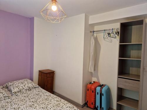 a bedroom with a bed and two suitcases in it at La Bergerie du Bois Rozet in Faux-Mazuras