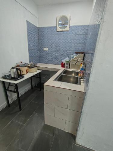 a small kitchen with a sink and a table at Perhentian Najmi Hotel in Perhentian Island