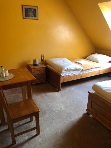 a room with two beds and a table in a room at Zajazd Pasterniki in Krościenko