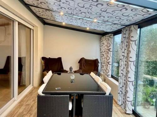 une pièce avec une table, des chaises et une fenêtre dans l'établissement Maison Cléopâtre 4 minutes à pied de la plage 3 chambres véranda jardin parking privé, à Wimereux