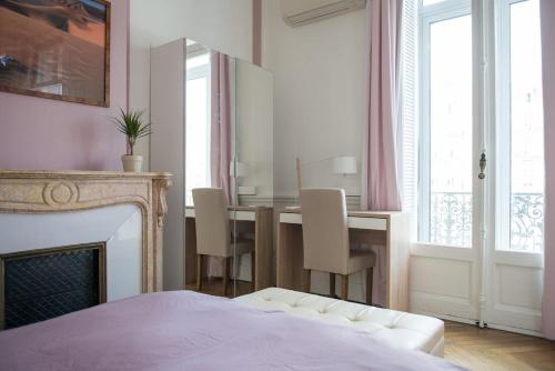 une chambre avec une table avec des chaises et une cheminée dans l'établissement 5-room apartment Place de la Comédie, à Montpellier