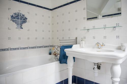 La salle de bains blanche est pourvue d'un lavabo et d'une baignoire. dans l'établissement 5-room apartment Place de la Comédie, à Montpellier