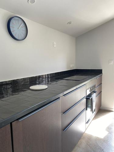 une grande cuisine avec une horloge murale dans l'établissement L'Oustalet Arles, à Arles