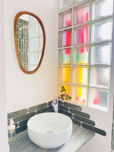 une salle de bain avec un lavabo blanc et un miroir dans l'établissement L'Oustalet Arles, à Arles